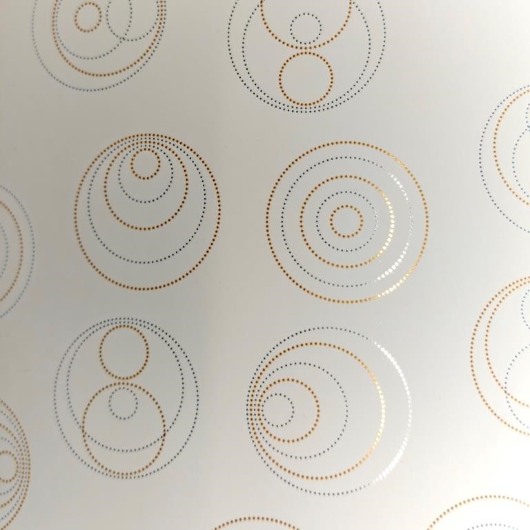 Gift wrapping paper mirror glossy dots in circle shape with a matte cream background.
 